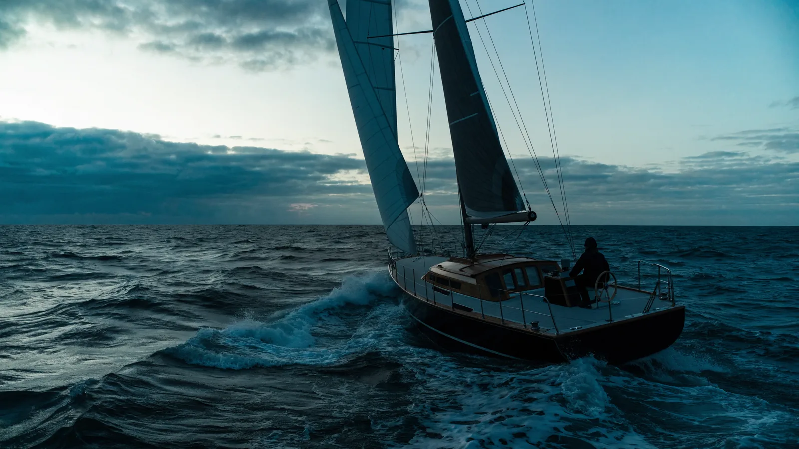 Velero en mar gruesa con el timonel a la rueda