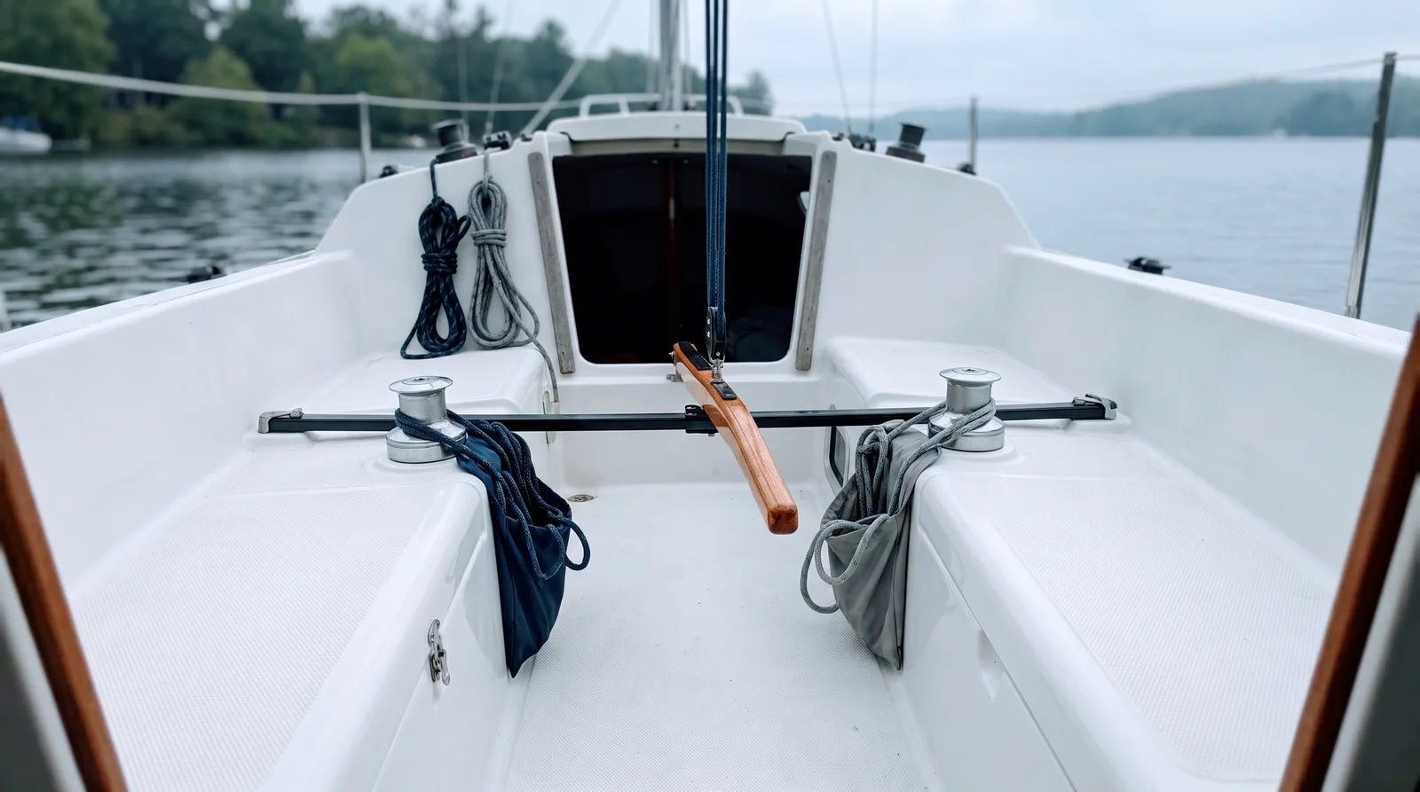 Bañera de un velero pequeño con caña, winches y cabos adujados.