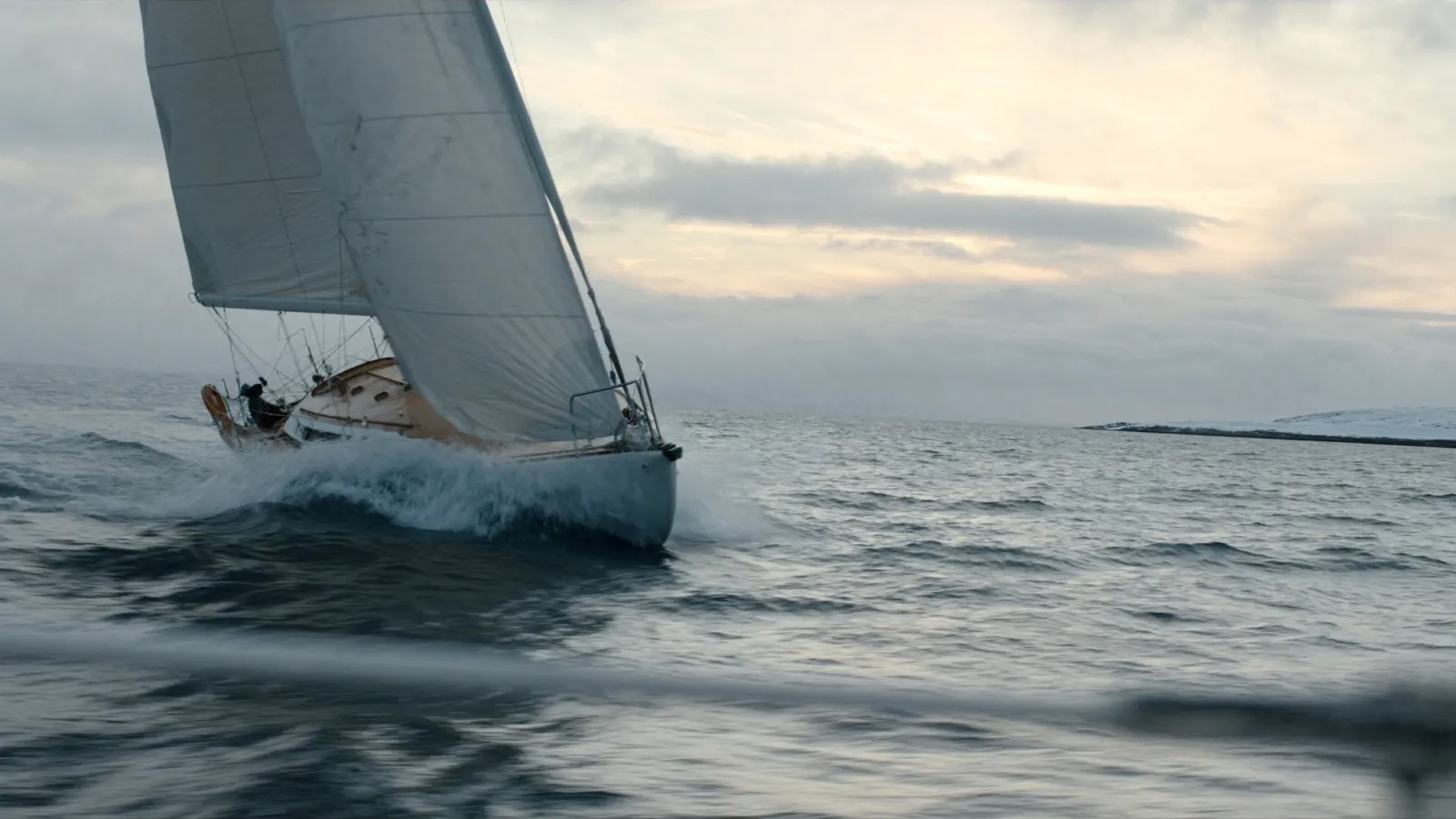 Velero de crucero escorado con rociones sobre la proa con viento fresco