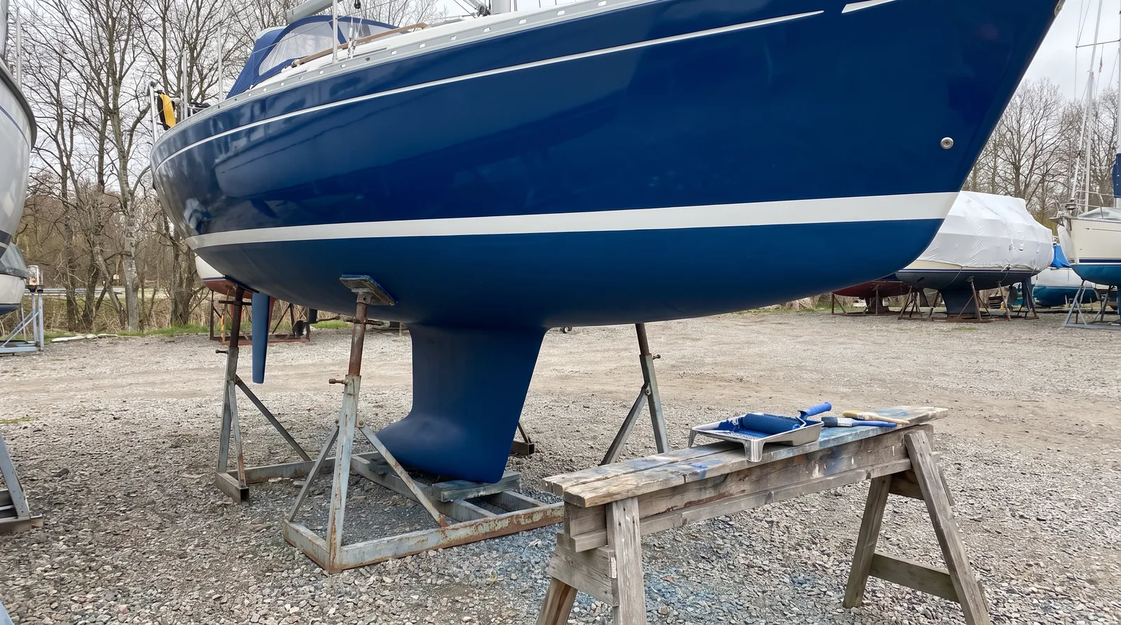 Obra viva de un velero recién pintada con antifouling azul oscuro en un varadero