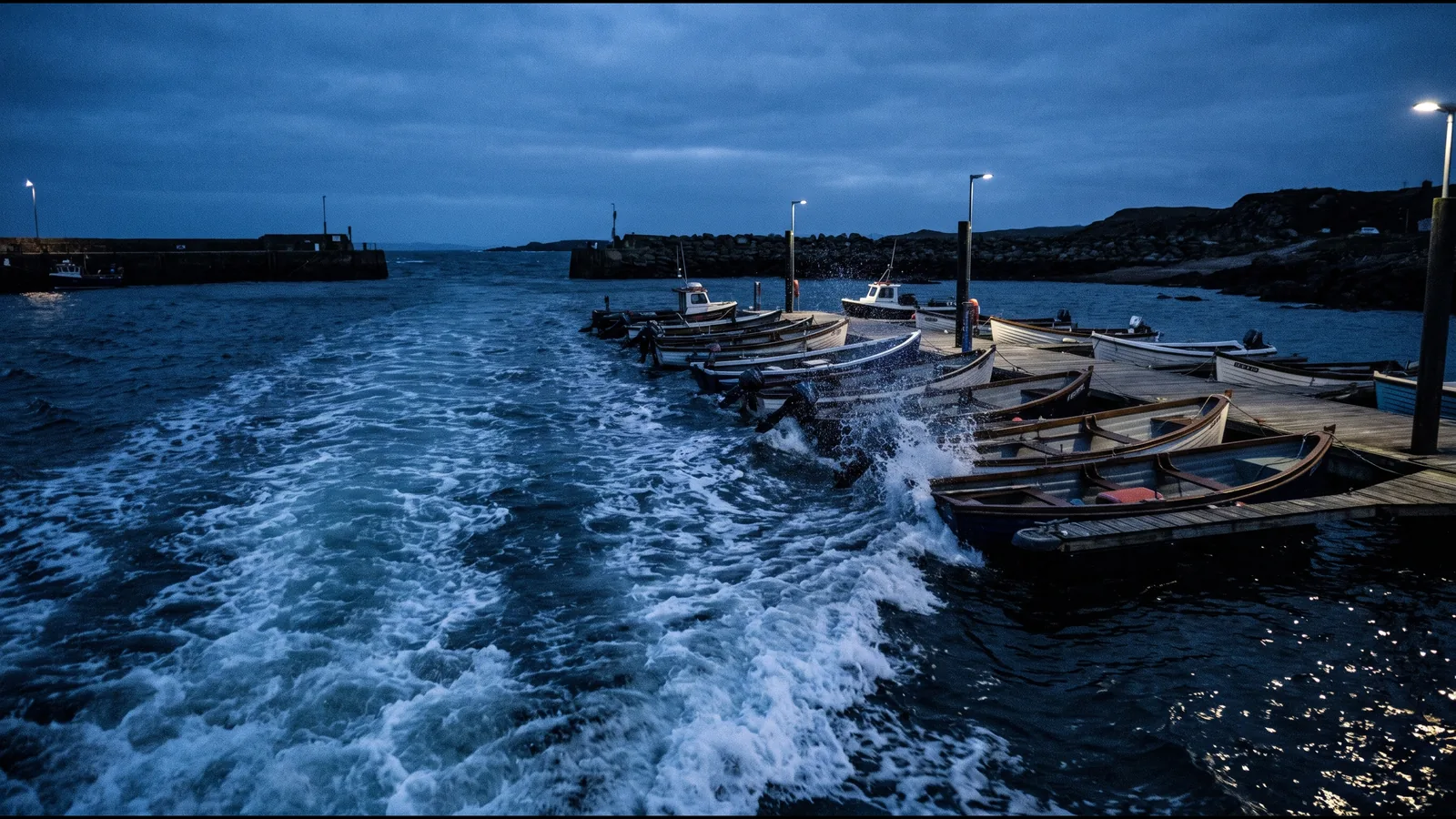 La ola de un barco que pasa alcanza al atardecer una fila de embarcaciones amarradas