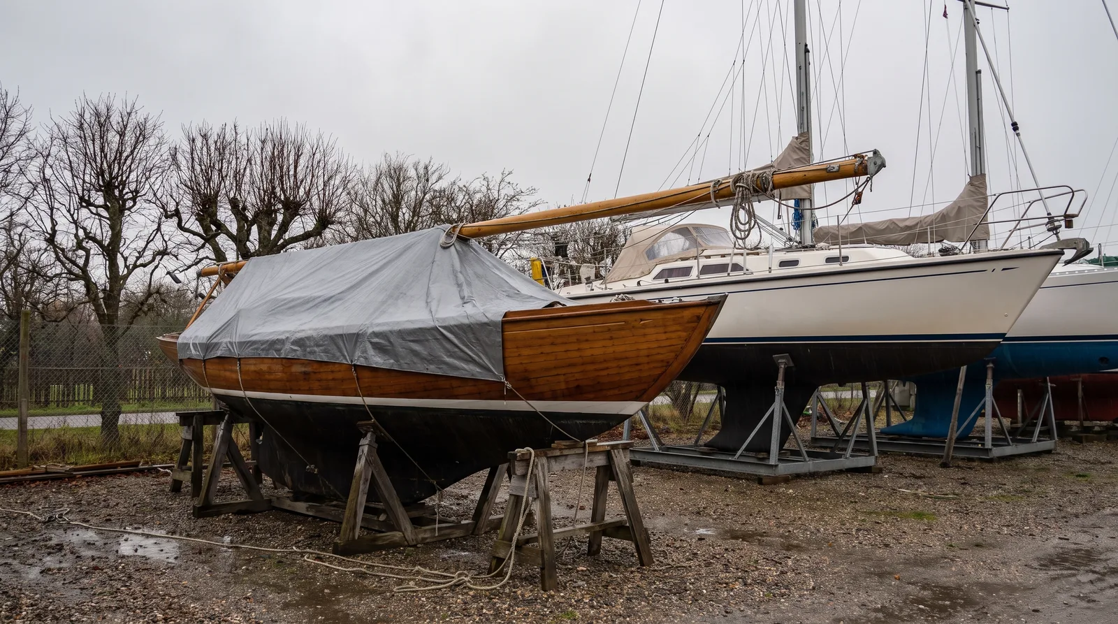 Invernada en seco: un velero arbolado sobre una cuna de acero y al lado otro barco con el mástil abatido sobre caballetes